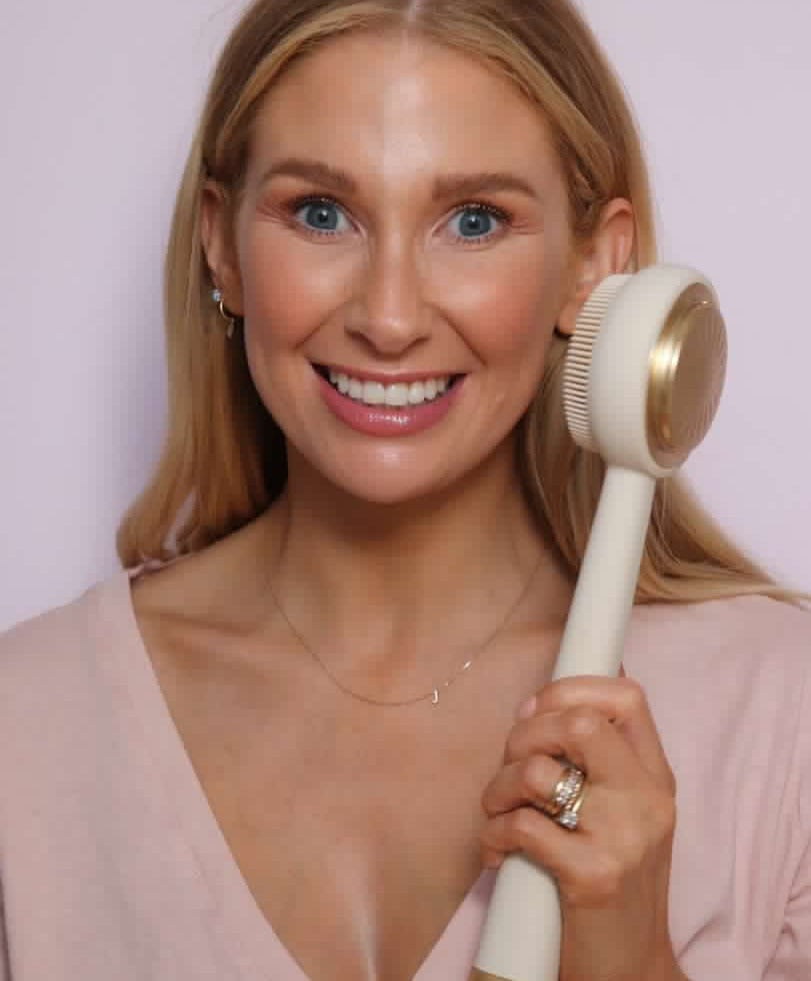 Zobelle Sonica Silicone Body Brush being held near the face of a female