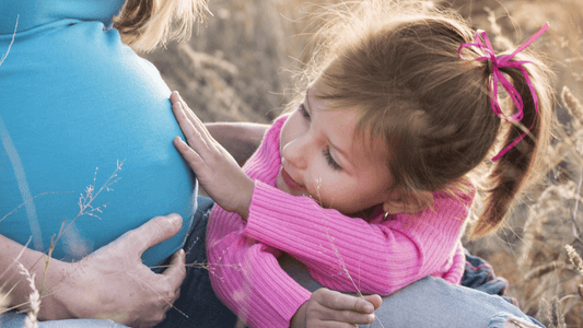 Little girl touching her mum's pregnant belly - growing baby bump - Babyheart Australia