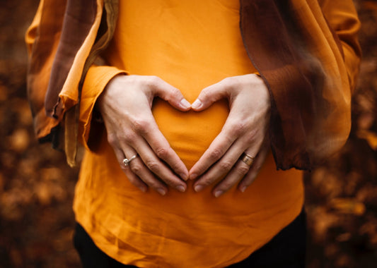Pregnant woman holding hands in a heart over her baby bump - BabyHeart Australia