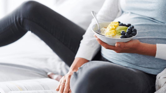 Pregnant woman eating bowl of fruit