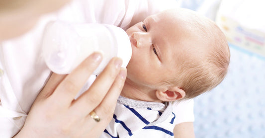 New mother bottle feeding her baby with breast milk