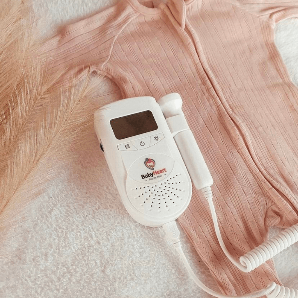 BabyHeart Standard Doppler lying on top on baby clothes photo shoot