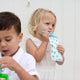 Lifestyle image of 2 toddlers. One is drinking from the Cherub Baby Maxi food pouch in blue