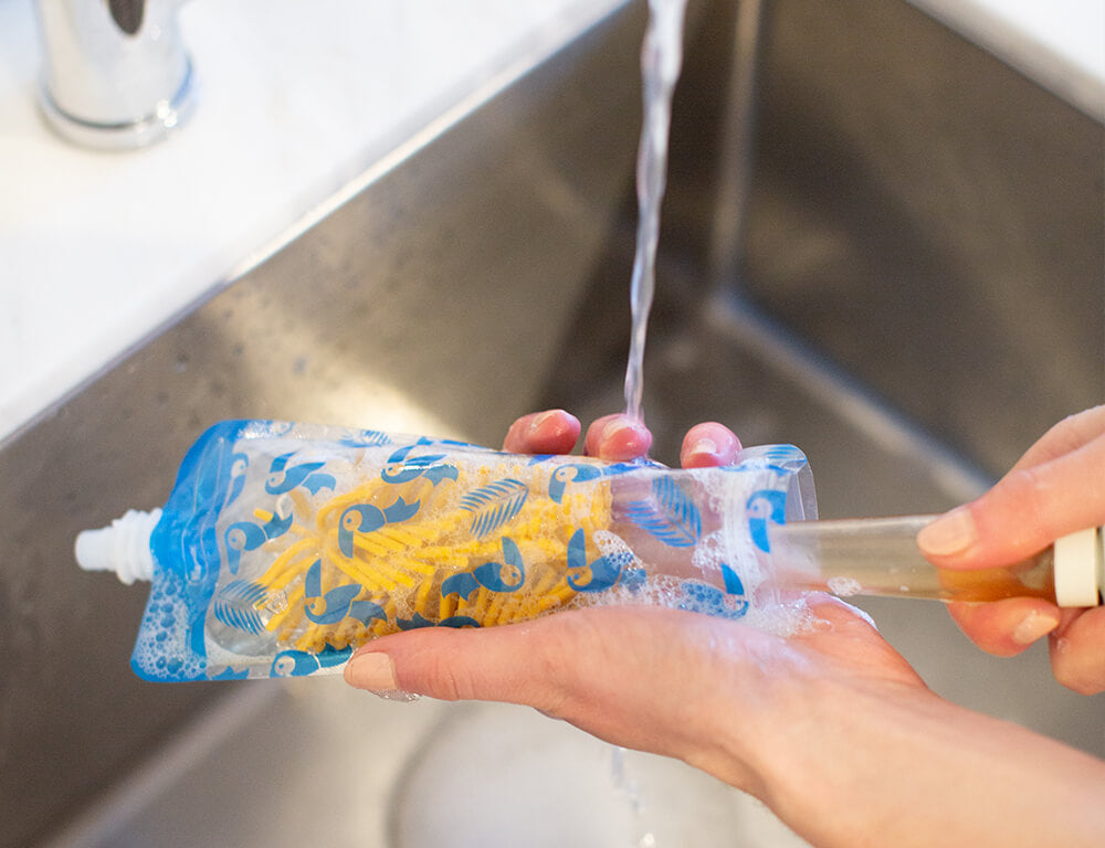 Image of someone washing the pouch from the base of the pouch that can be opened