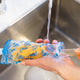 Image of someone washing the pouch from the base of the pouch that can be opened