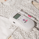 BabyHeart Standard Doppler lying on a few baby clothes